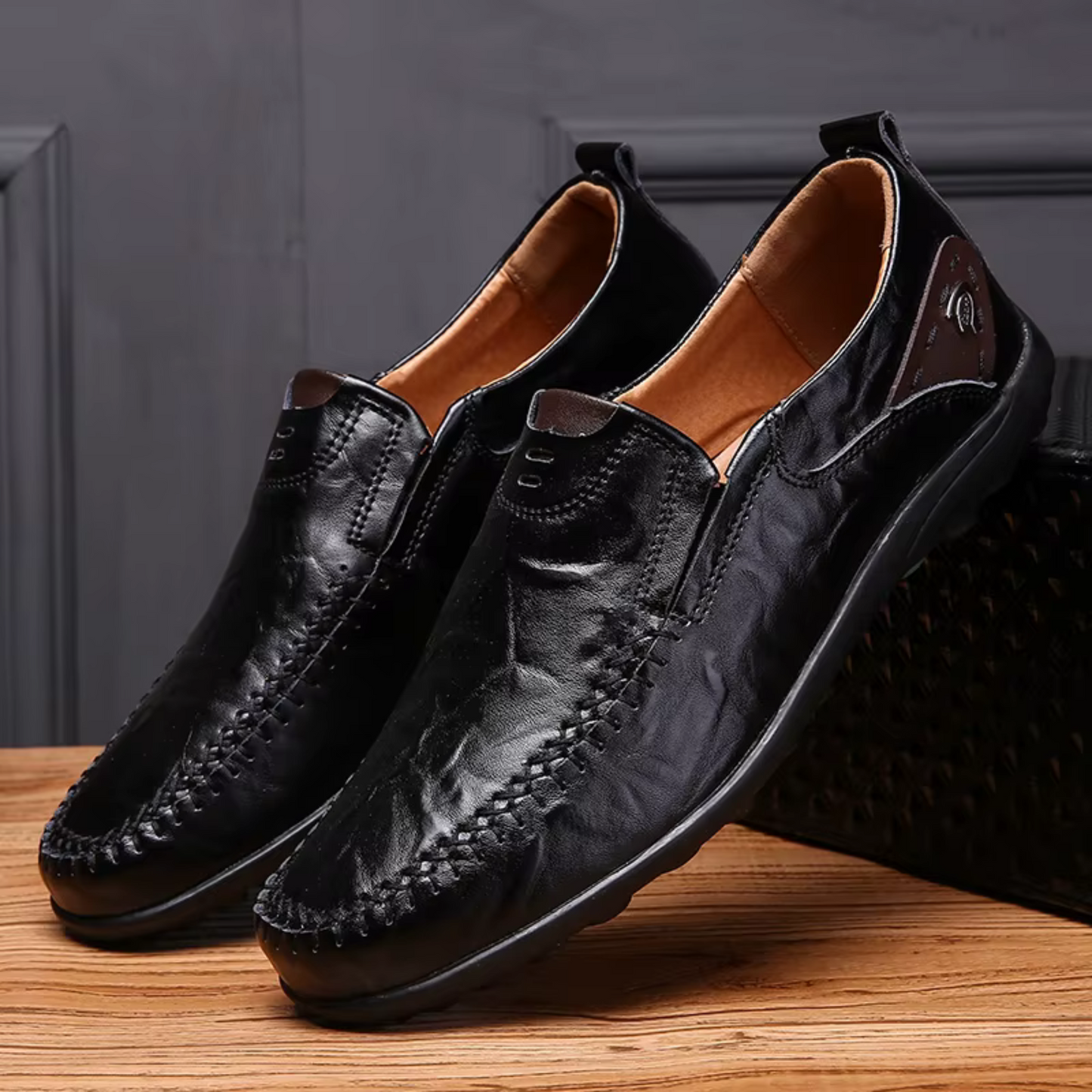 Black leather slip-on moccasins with detailed stitching and cushioned interior for all-day comfort and versatile style